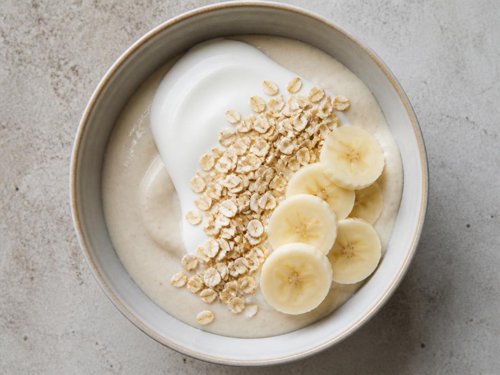 Bowl of Nigerian pap topped with pasteurised yoghurt, oats and sliced banana