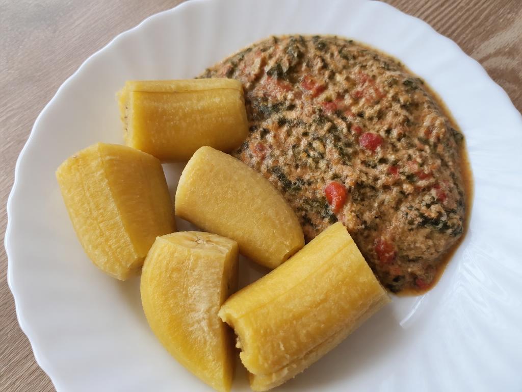 Bowl of boiled plantain with mild groundnut and tomato vegetable sauce