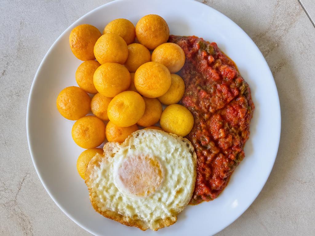 Nigerian masa rice cakes served with cooked egg and tomato vegetable sauce