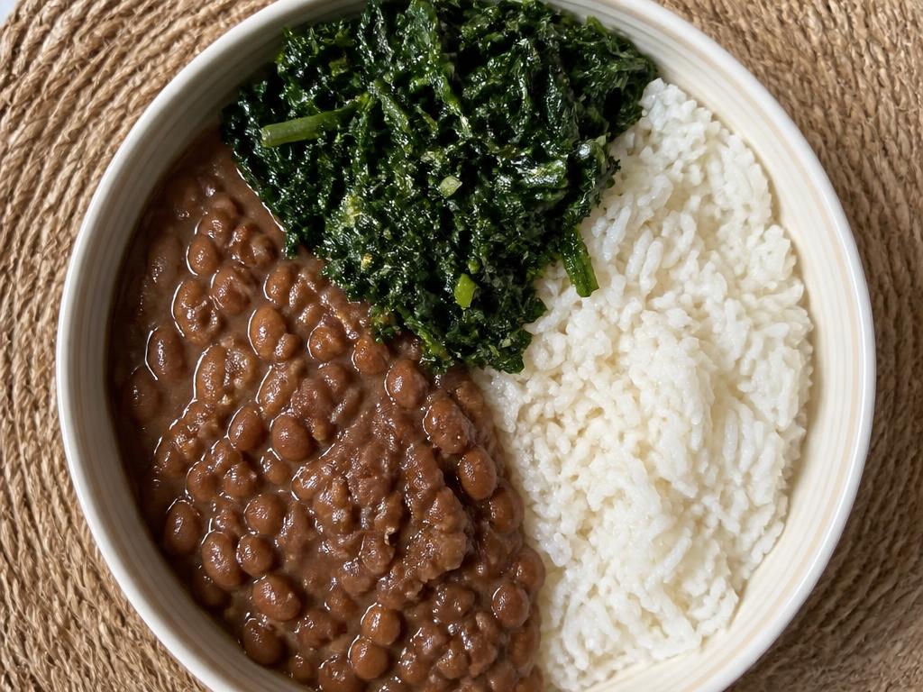 Bowl of Nigerian cooked beans with ugu leaves and white rice